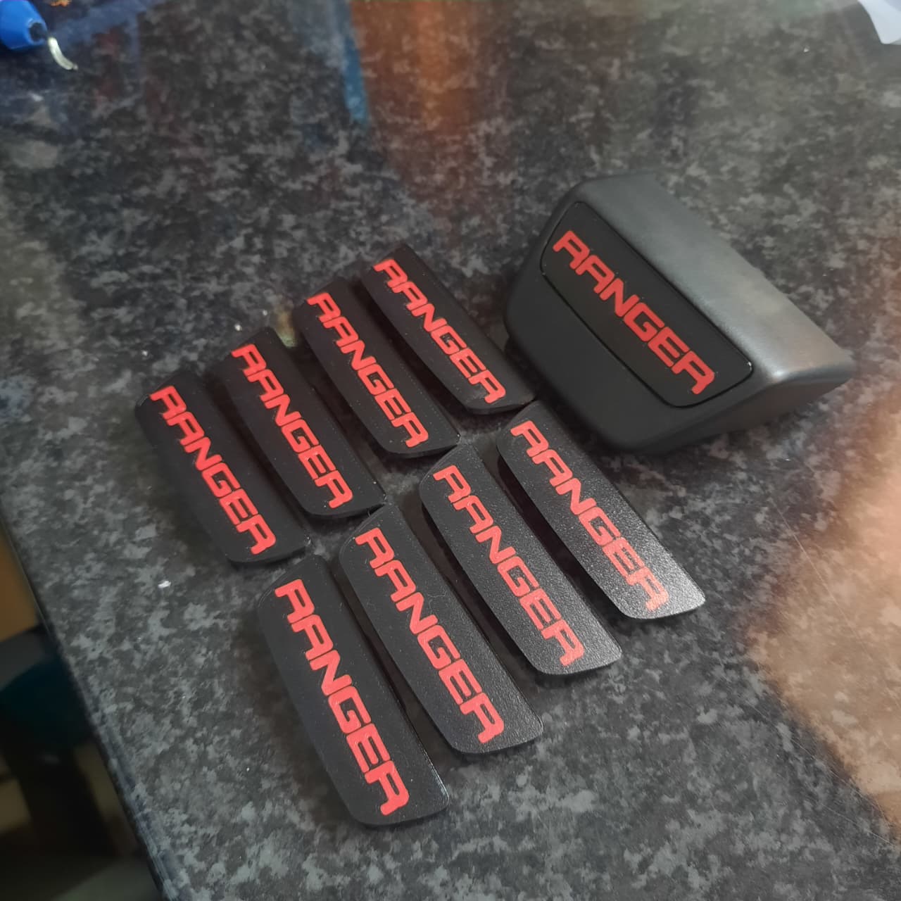 8 red Ford Ranger enc caps on a table
