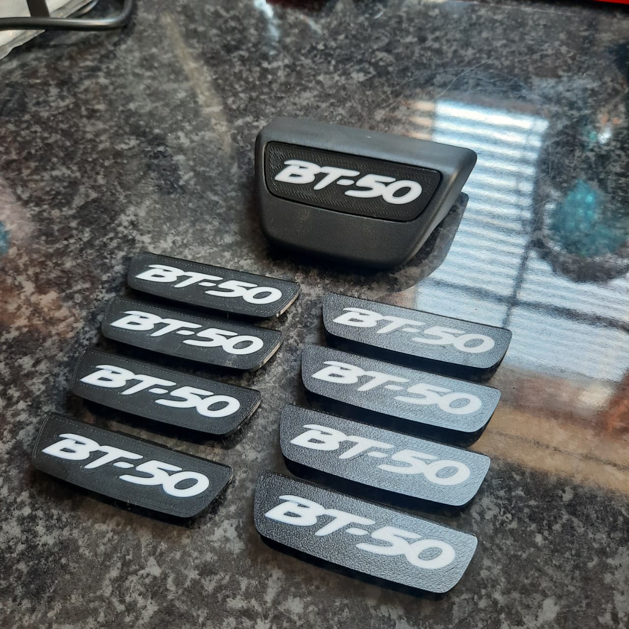 Black 'BT-50' end caps arranged on a table