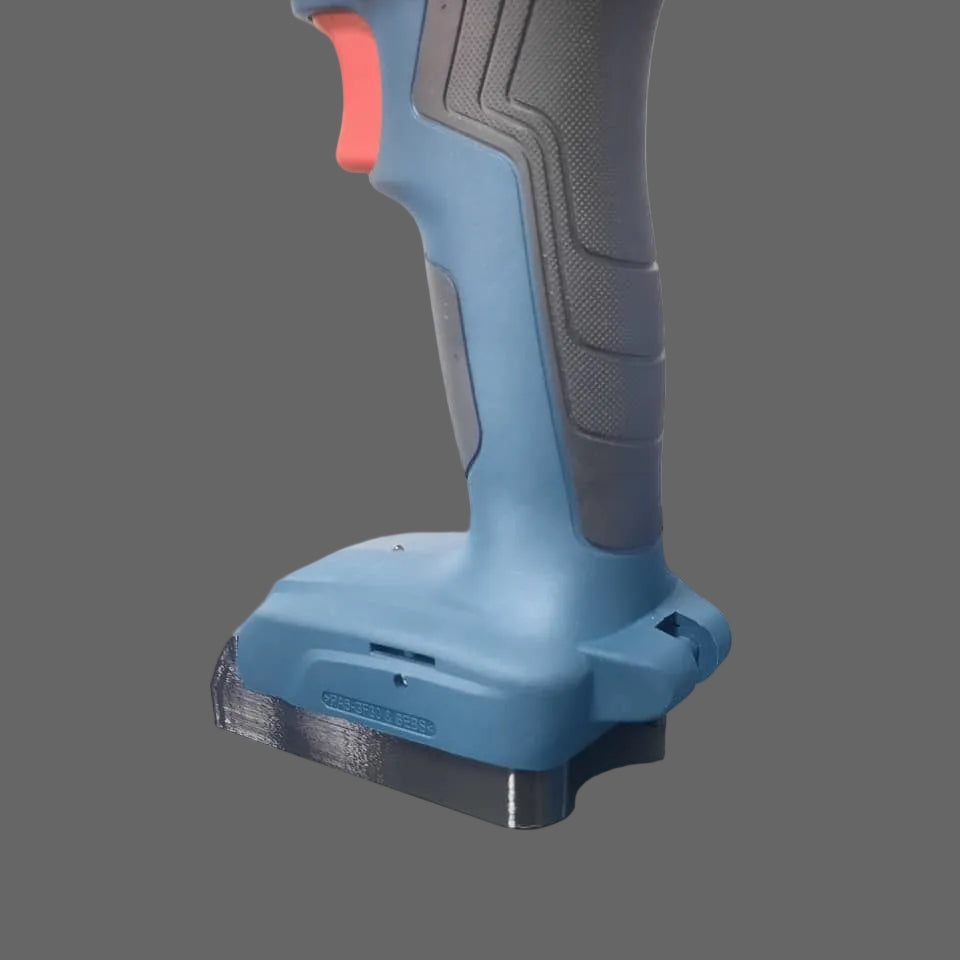 Blue and black cordless drill on a grey surface with a blurred background