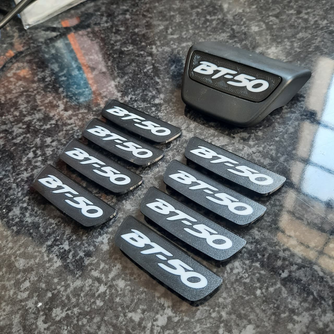 Black 'BT-50' branded end caps on a textured surface