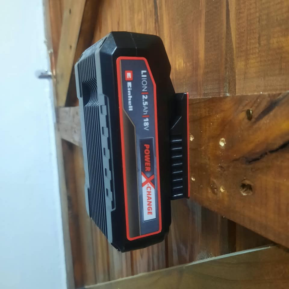A black and red Einhell Lithium 2.0Ah battery pack resting on a rustic wooden surface.