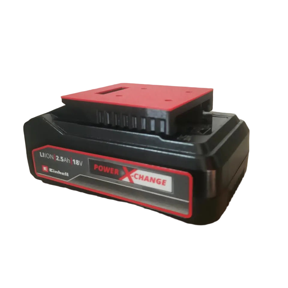 A black and red Einhell 18V PowerXChange Lithium-ion battery resting on a brown cardboard box in an indoor setting.