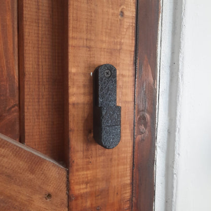 Black fishing reel mount on a wooden door