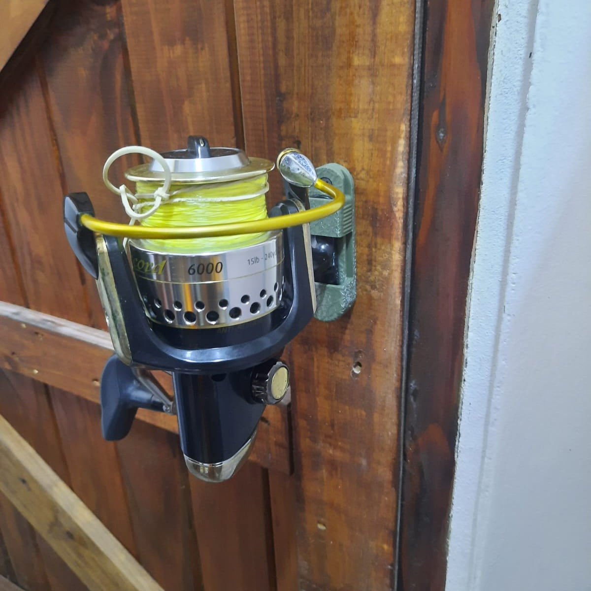 Fishing reel with yellow line on a wooden surface
