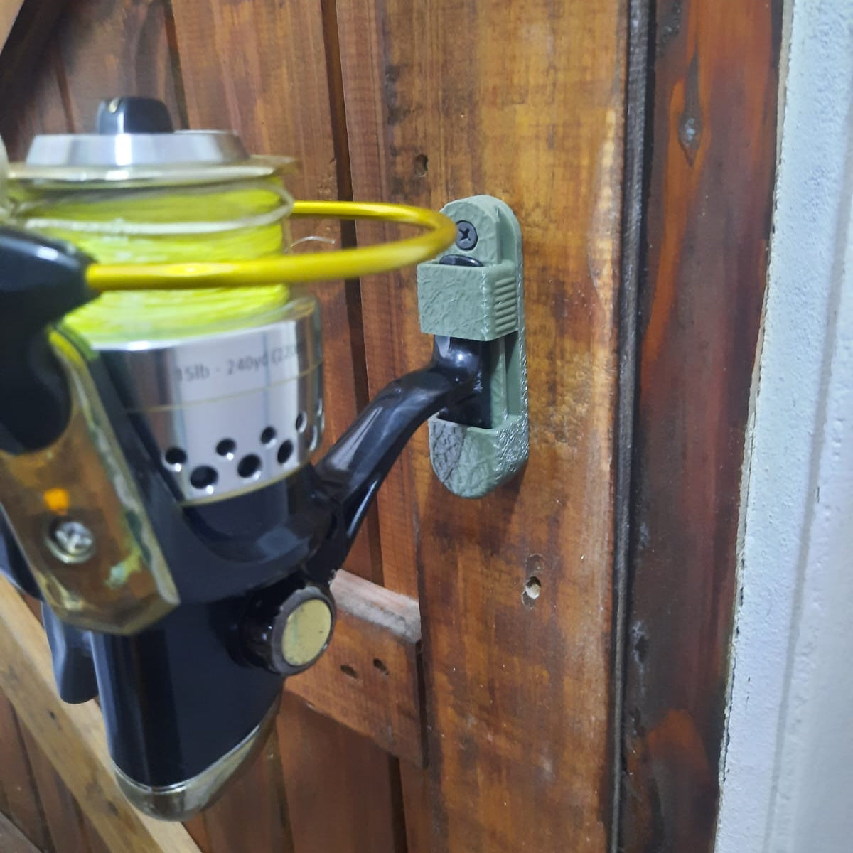 Fishing reel attached to a wooden surface