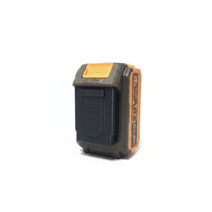 A cordless power tool battery pack with a black and orange design, standing upright on a reflective black surface against a plain light background.