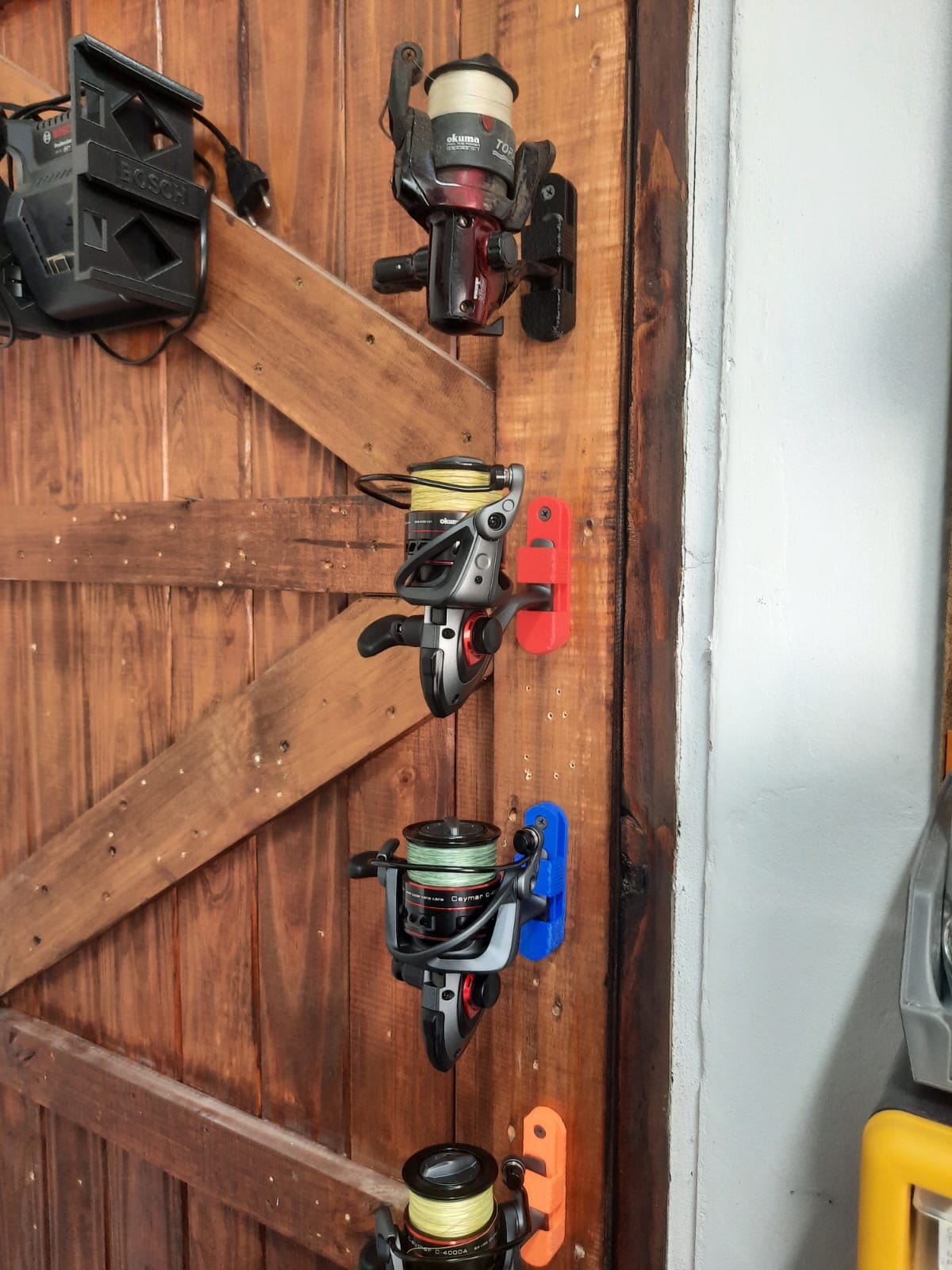 Collection of fishing reels mounted on a wooden door