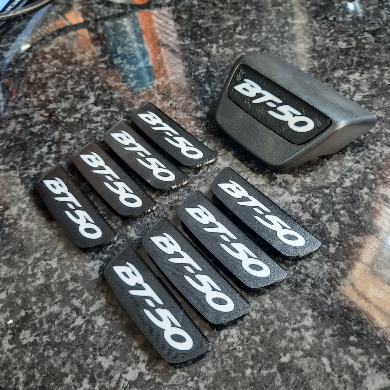 Black 'BT-50' end caps on a reflective surface